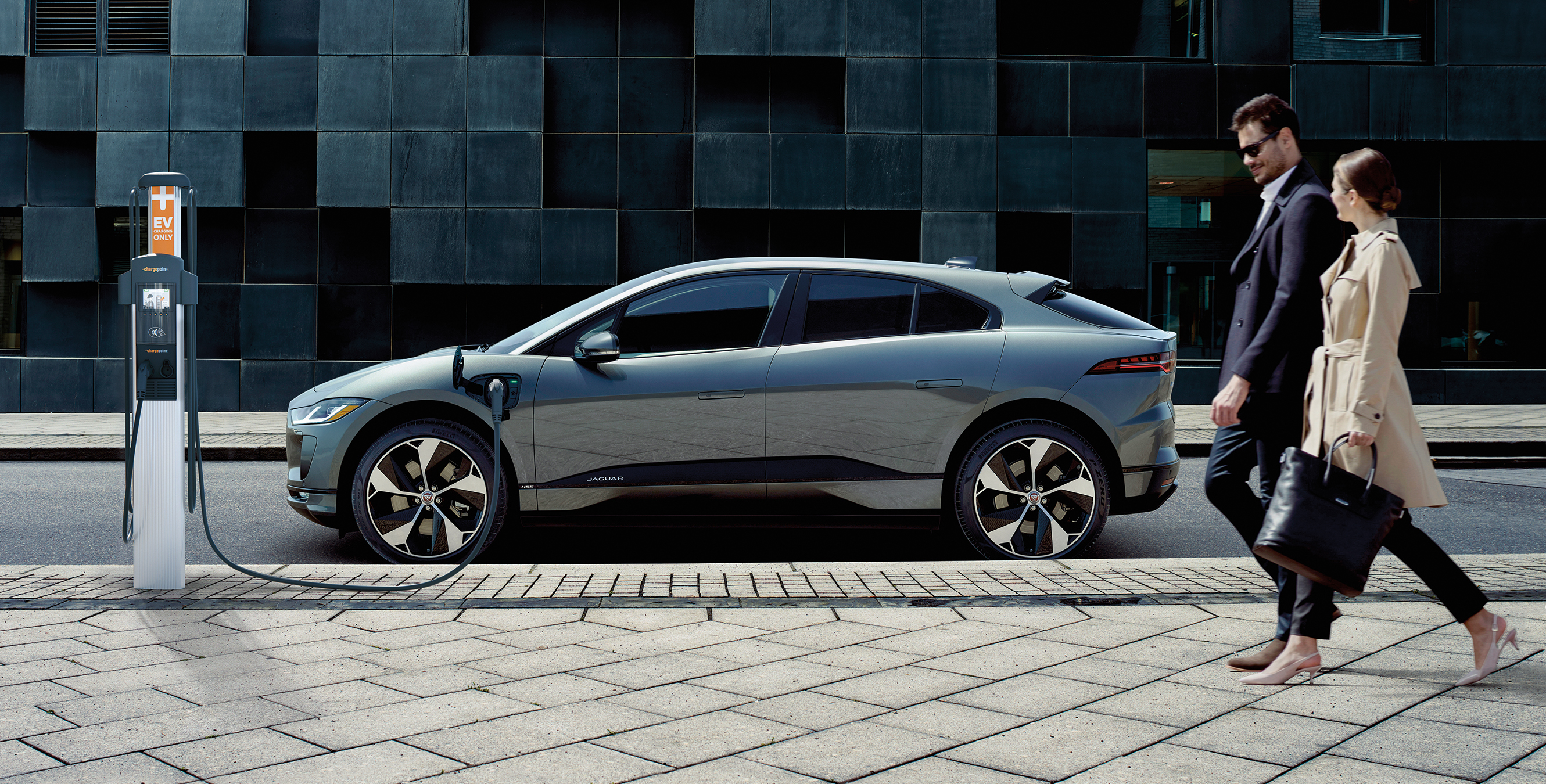 Couple walking next to a Jaguar I-PACE